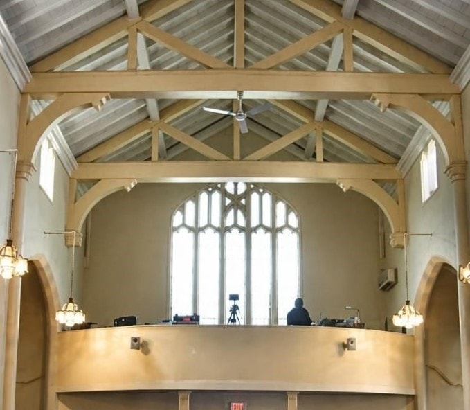 Sanctuary interior — timber trusses and curved media loft