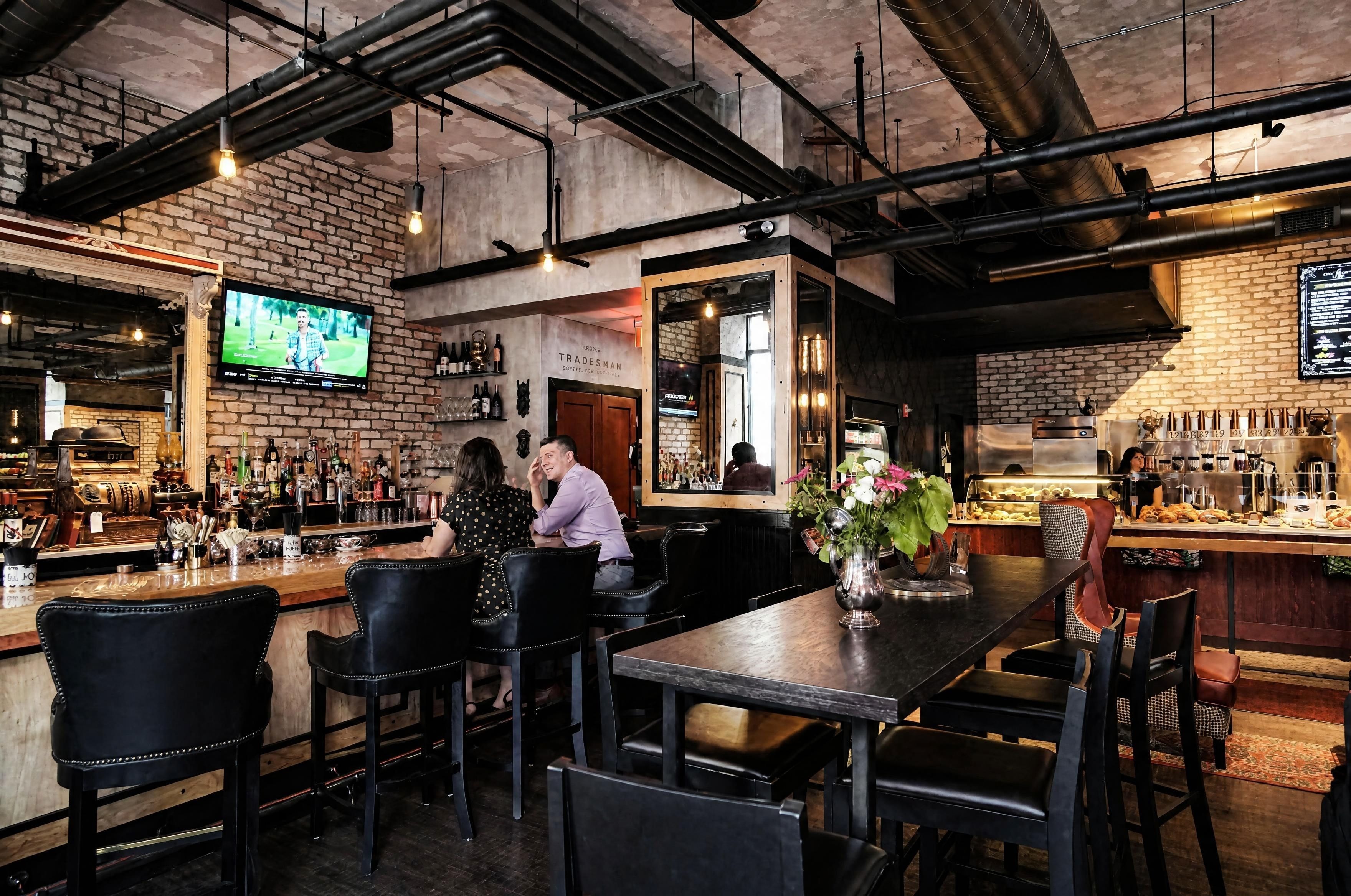 Bar and dining area with exposed brick and industrial ceiling